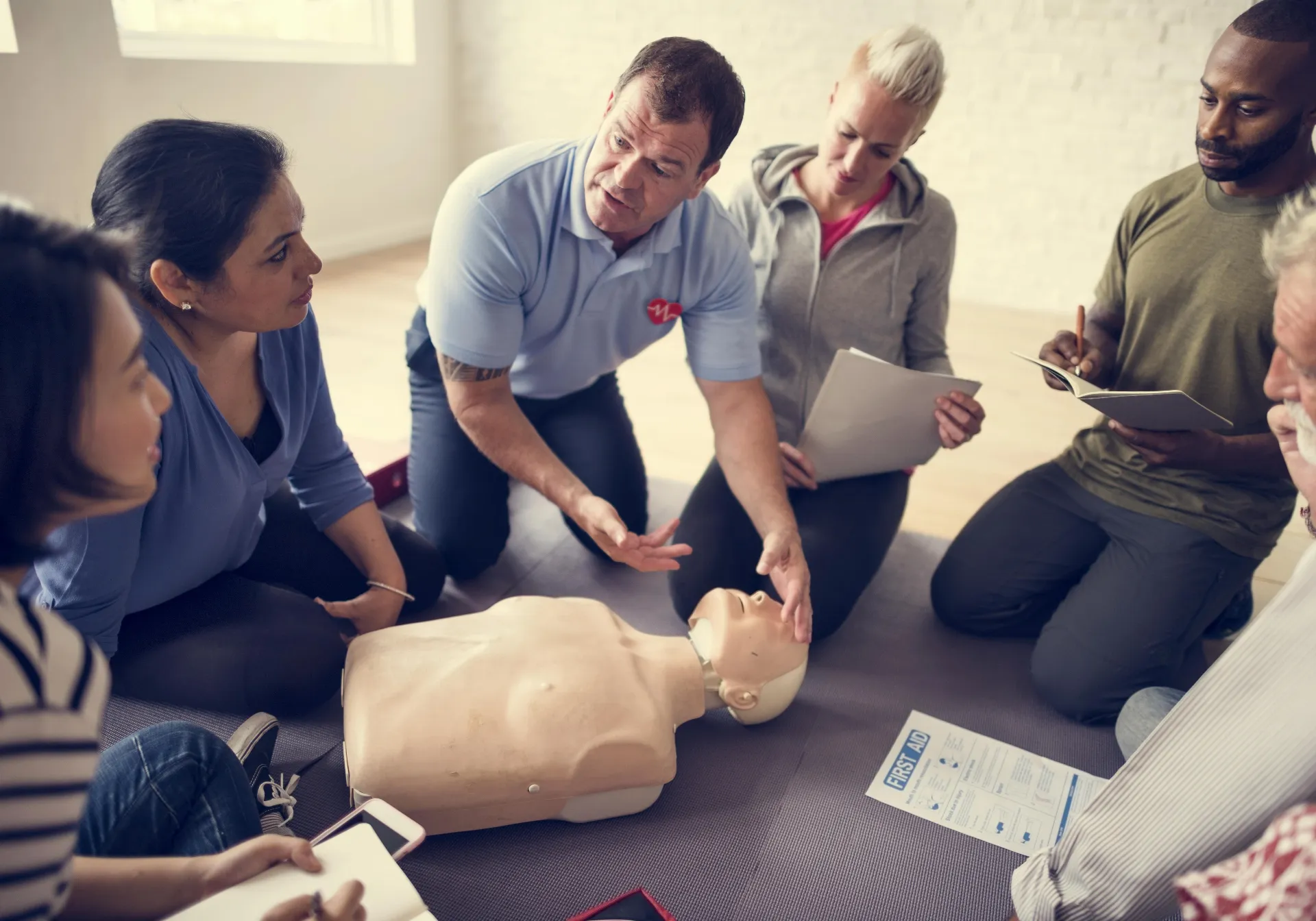 A skilled man demonstrating proper CPR techniques to others.