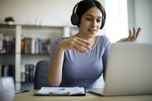 A young woman with headphones taking part in Busy Bees Education and Training’s free online courses.